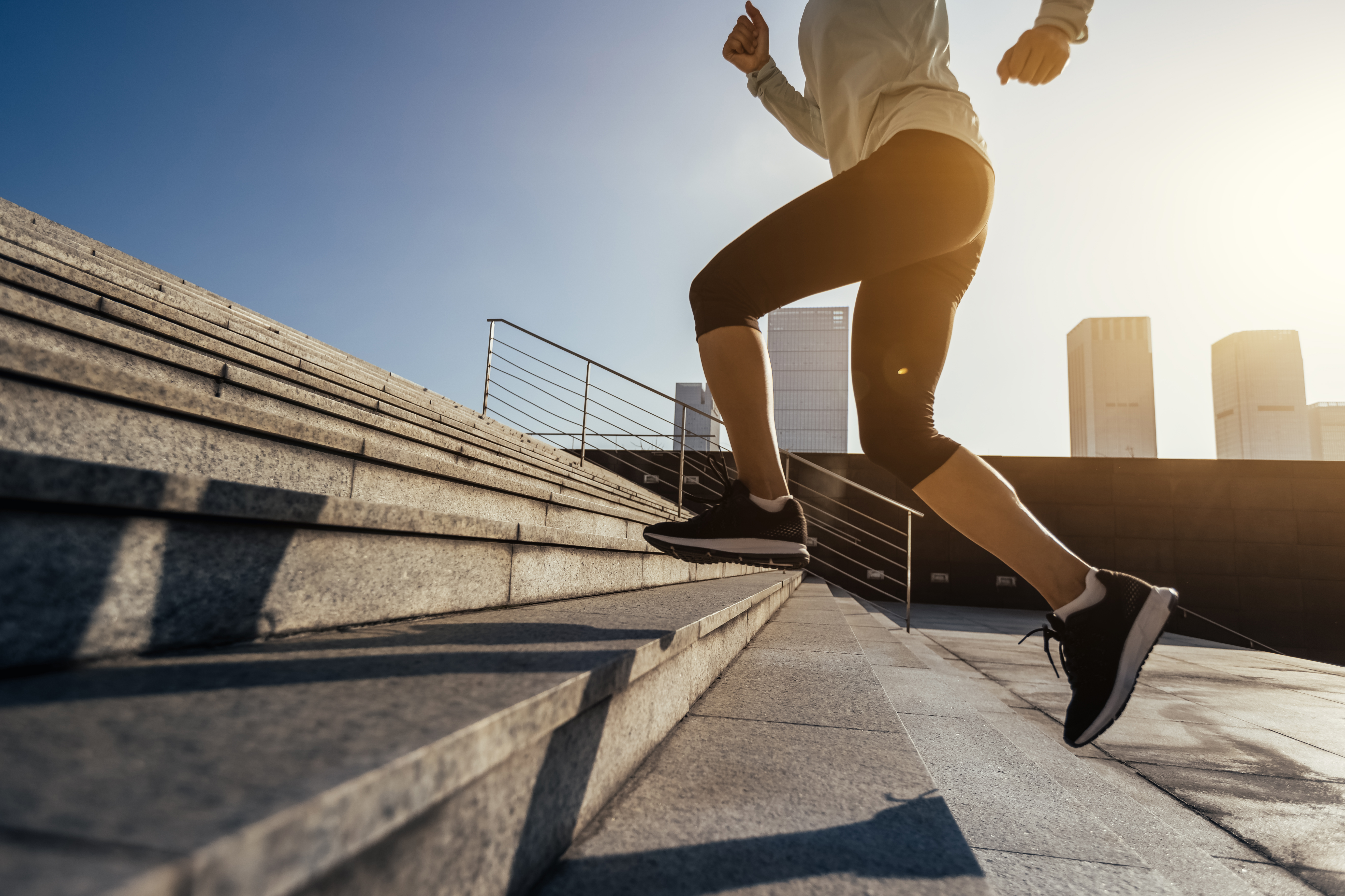 Fitness sports woman running up stairs in city
